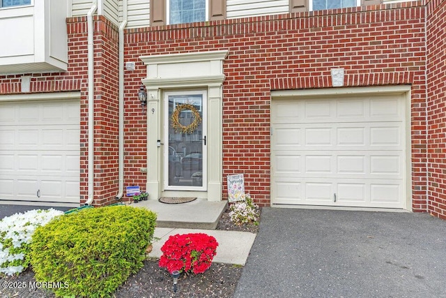 9 Olivia Dr, Tinton Falls, NJ 07712 - doorway to property featuring brick siding, a garage, and asphalt driveway