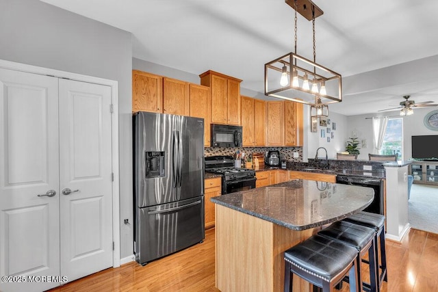 9 Olivia Dr, Tinton Falls, NJ 07712 - kitchen featuring black appliances, light wood-style floors, a ceiling fan, and a breakfast bar