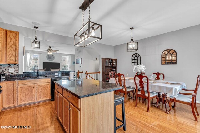 9 Olivia Dr, Tinton Falls, NJ 07712 - kitchen featuring dishwashing machine, light wood-type flooring, ceiling fan, and a breakfast bar