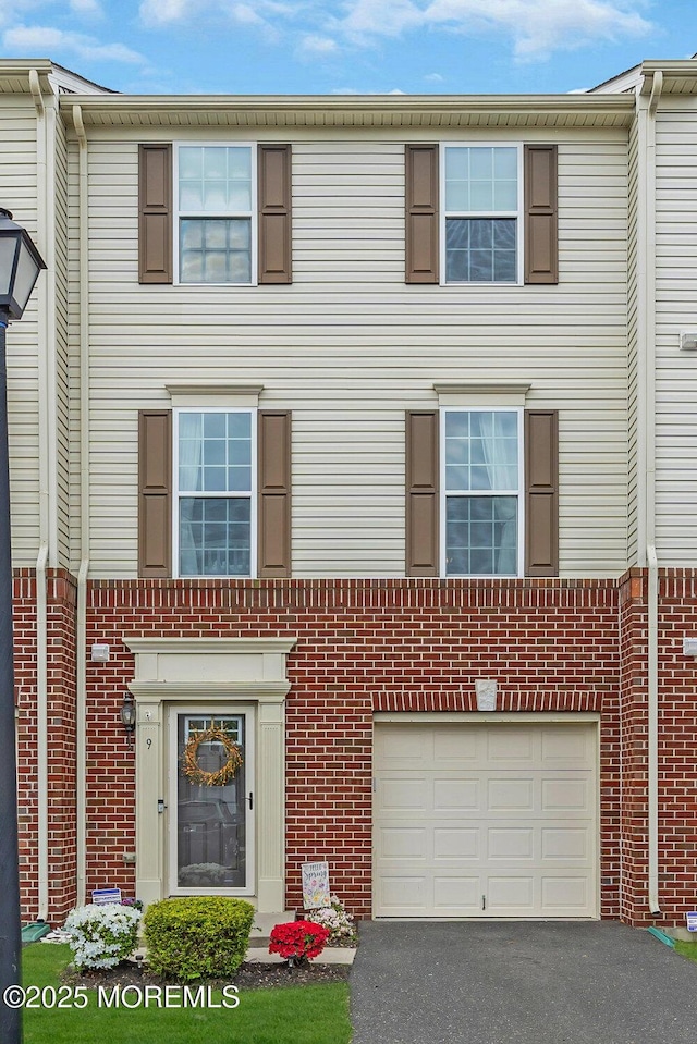 9 Olivia Dr, Tinton Falls, NJ 07712 - townhome / multi-family property featuring asphalt driveway, an attached garage, and brick siding
