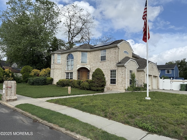 300 Allenhurst Ave, Neptune Township, NJ 07753 - view of front of home with roof mounted solar panels, a garage, brick siding, and concrete driveway