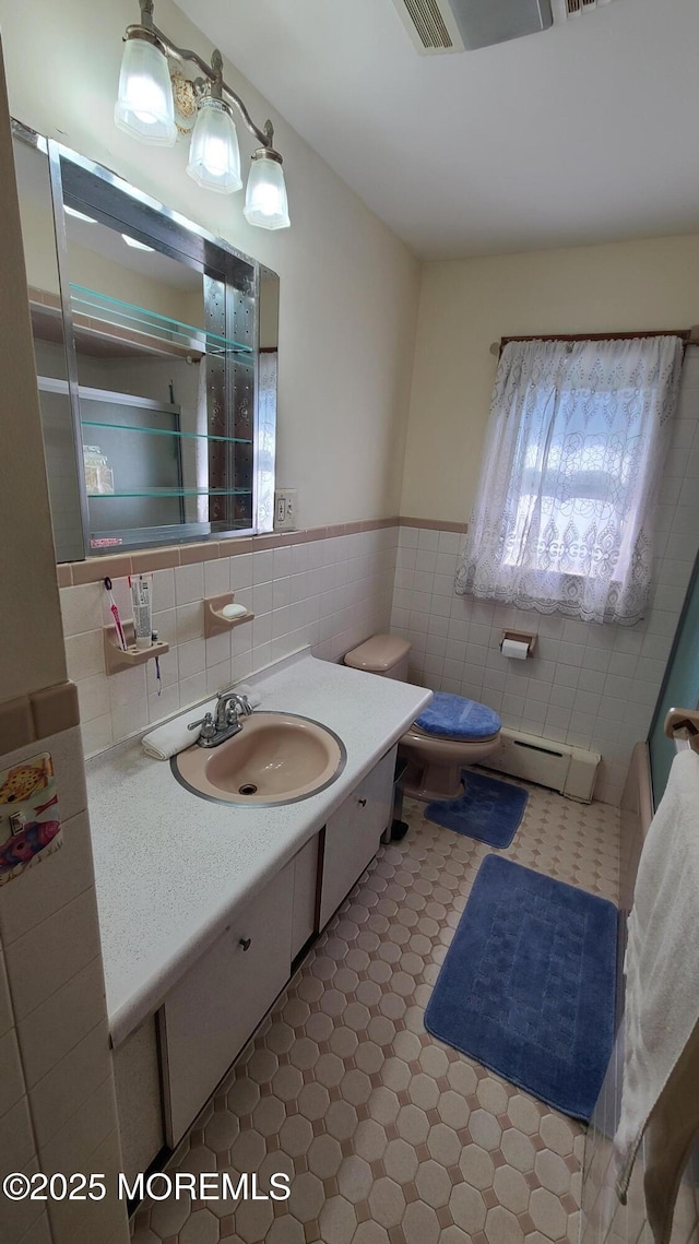 354 Alpine St, Perth Amboy City, NJ 08861 - bathroom with a baseboard radiator, tile walls, vanity, wainscoting, and tile patterned floors