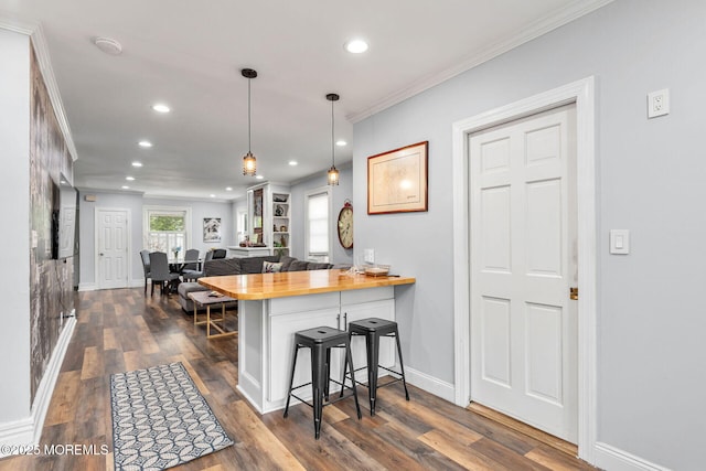 51 Oakland St, Red Bank, NJ 07701 - kitchen featuring a breakfast bar area, crown molding, recessed lighting, wood counters, and dark wood-type flooring