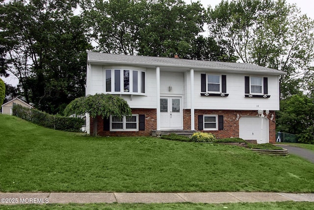 18 Kingsport Dr, Howell, NJ 07731 - raised ranch featuring asphalt driveway, a front yard, a garage, and brick siding