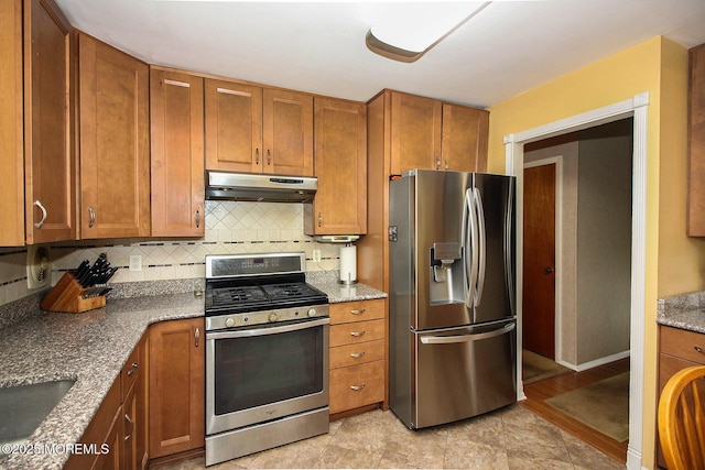 18 Kingsport Dr, Howell, NJ 07731 - kitchen with stainless steel appliances, under cabinet range hood, brown cabinetry, decorative backsplash, and stone countertops