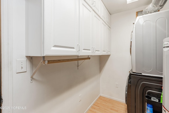 66 Cedar Swamp Rd, Jackson, NJ 08527 - laundry room with stacked washer and clothes dryer, light wood-type flooring, and cabinet space