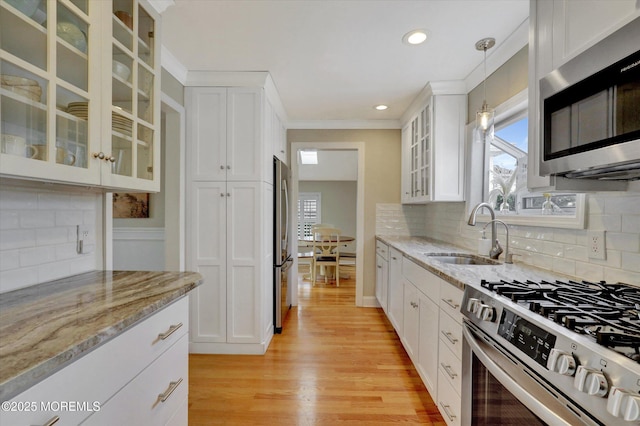 206 Chicago Ave, Point Pleasant Beach, NJ 08742 - kitchen with stainless steel appliances, a sink, light wood-style flooring, white cabinets, and ornamental molding
