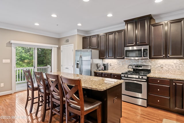 38 Phillip E Frank Way Unit 38, Cliffwood, NJ 07721 - kitchen featuring stainless steel appliances, light wood-style flooring, a kitchen island, a breakfast bar, and backsplash