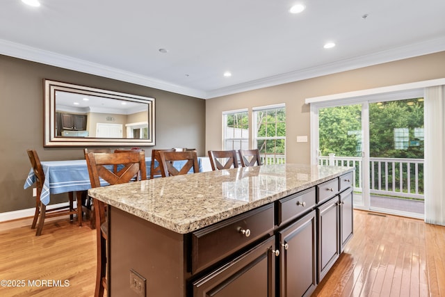 38 Phillip E Frank Way Unit 38, Cliffwood, NJ 07721 - kitchen featuring light wood finished floors, ornamental molding, a breakfast bar, light stone countertops, and a center island
