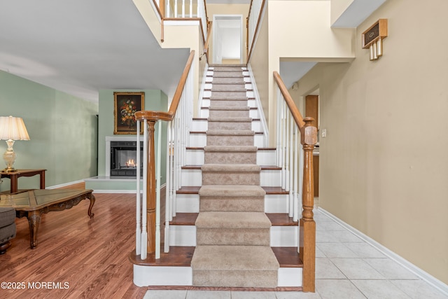 74 Mc Kinley Dr, Ocean Twp, NJ 07712 - staircase with a warm lit fireplace and baseboards