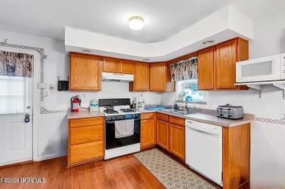 532 Georgia Tavern Rd, Howell, NJ 07731 - kitchen with white appliances, under cabinet range hood, light countertops, and brown cabinets