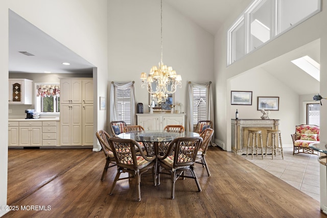 14 W St, Monmouth Beach, NJ 07750 - dining area featuring high vaulted ceiling, a chandelier, healthy amount of natural light, and dark wood-style flooring