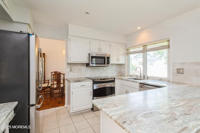 892 Eaglehurst Rd, Toms River, NJ 08753 - kitchen featuring appliances with stainless steel finishes, white cabinets, decorative backsplash, light tile patterned floors, and light stone countertops