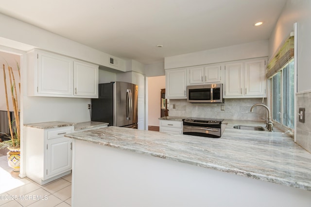 892 Eaglehurst Rd, Toms River, NJ 08753 - kitchen featuring stainless steel appliances, a peninsula, white cabinets, light stone counters, and backsplash
