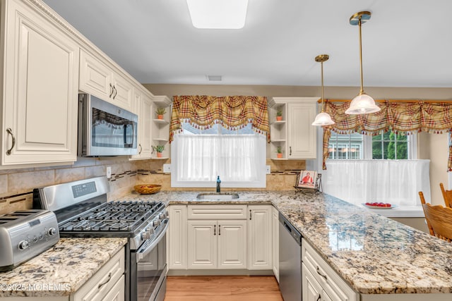 37 Normanton Ave, Manchester, NJ 08759 - kitchen featuring appliances with stainless steel finishes, open shelves, a peninsula, decorative backsplash, and light stone countertops