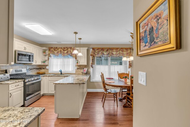 37 Normanton Ave, Manchester, NJ 08759 - kitchen featuring appliances with stainless steel finishes, white cabinetry, a peninsula, light wood-type flooring, and backsplash
