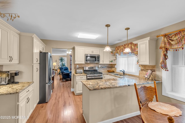 37 Normanton Ave, Manchester, NJ 08759 - kitchen with appliances with stainless steel finishes, a peninsula, light wood-style floors, and light stone countertops