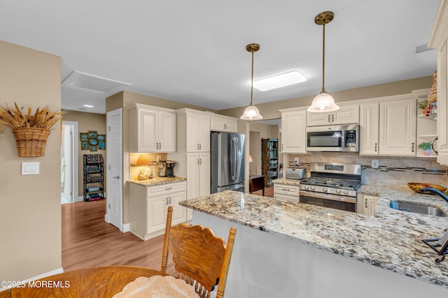 37 Normanton Ave, Manchester, NJ 08759 - kitchen featuring stainless steel appliances, decorative backsplash, light wood-style flooring, and light stone counters