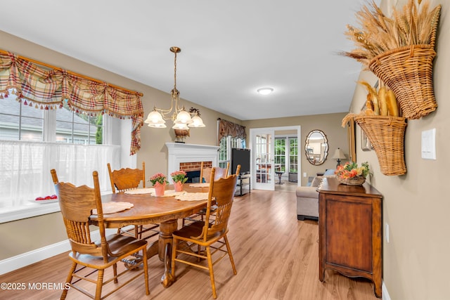 37 Normanton Ave, Manchester, NJ 08759 - dining area with light wood finished floors, a brick fireplace, and a chandelier