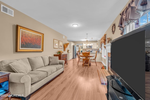 37 Normanton Ave, Manchester, NJ 08759 - living room with a chandelier, light wood finished floors, and a fireplace