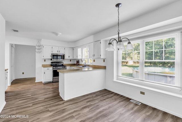4 W Dickens Ct, Jackson, NJ 08527 - kitchen with appliances with stainless steel finishes, a sink, a peninsula, white cabinets, and baseboards