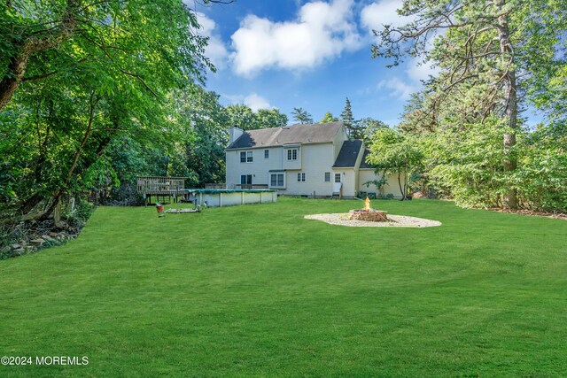 4 W Dickens Ct, Jackson, NJ 08527 - view of grassy yard featuring a fire pit, an outdoor pool, and a wooden deck