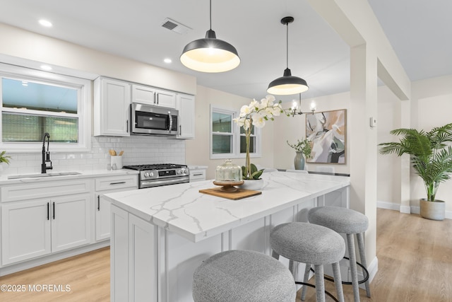 190 Ravenwood Blvd, Barnegat, NJ 08005 - kitchen featuring stainless steel appliances, a sink, a kitchen island, tasteful backsplash, and light stone counters