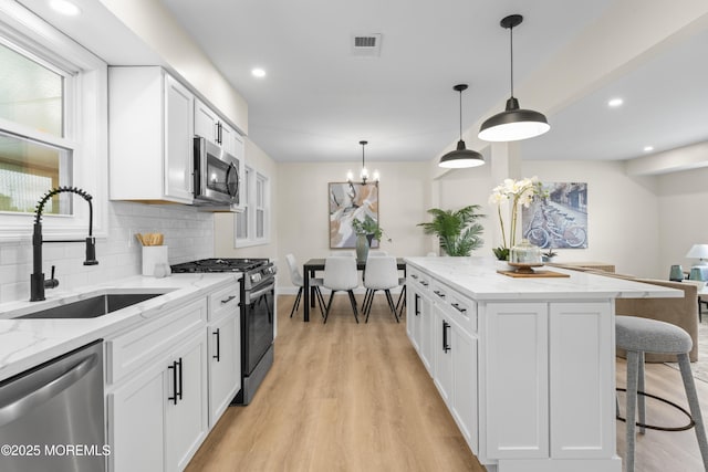 190 Ravenwood Blvd, Barnegat, NJ 08005 - kitchen with appliances with stainless steel finishes, a sink, a kitchen bar, tasteful backsplash, and white cabinetry