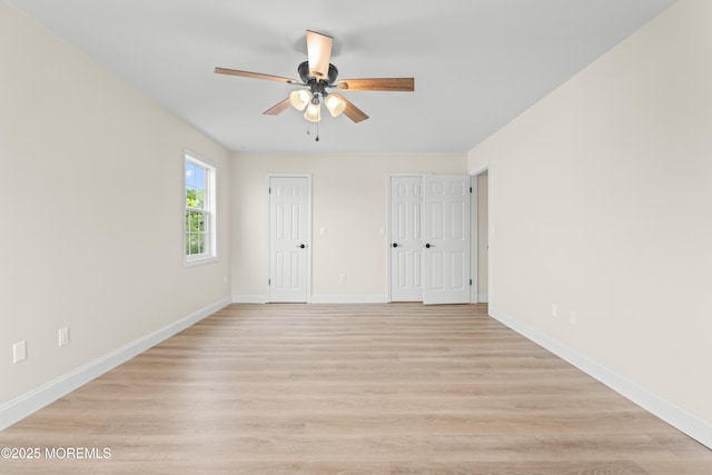 190 Ravenwood Blvd, Barnegat, NJ 08005 - unfurnished bedroom with two closets, baseboards, light wood-style floors, and a ceiling fan