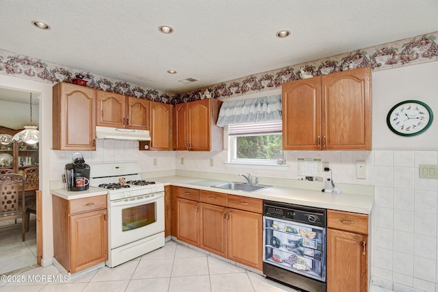 28 Tulip Ct, Howell, NJ 07731 - kitchen with under cabinet range hood, gas range gas stove, dishwasher, a sink, and light tile patterned floors