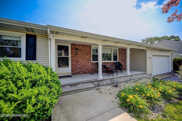 855 Derry Dr, Toms River, NJ 08753 - view of exterior entry with covered porch, a garage, brick siding, and asphalt driveway