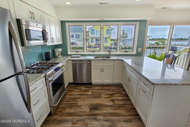 443 Harding Ave, Ortley Beach, NJ 08751 - kitchen with appliances with stainless steel finishes, a peninsula, dark wood-style floors, light stone counters, and recessed lighting