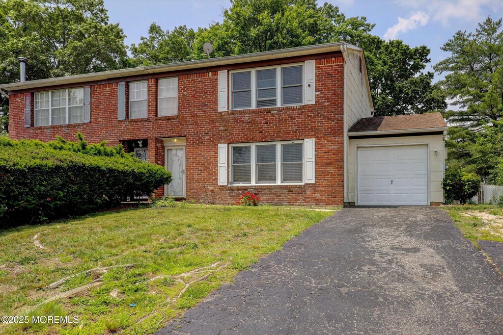 73 Barnegat Blvd S, Barnegat, NJ 08005 - colonial home featuring a garage, asphalt driveway, a front yard, and brick siding