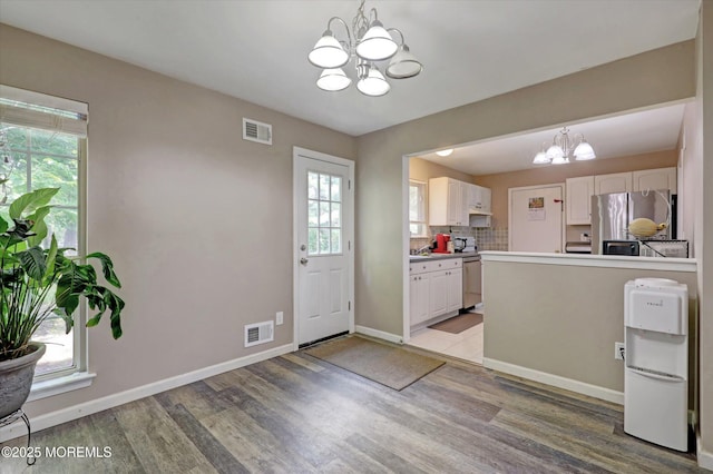 73 Barnegat Blvd S, Barnegat, NJ 08005 - kitchen featuring a chandelier, freestanding refrigerator, light wood finished floors, white cabinets, and a peninsula