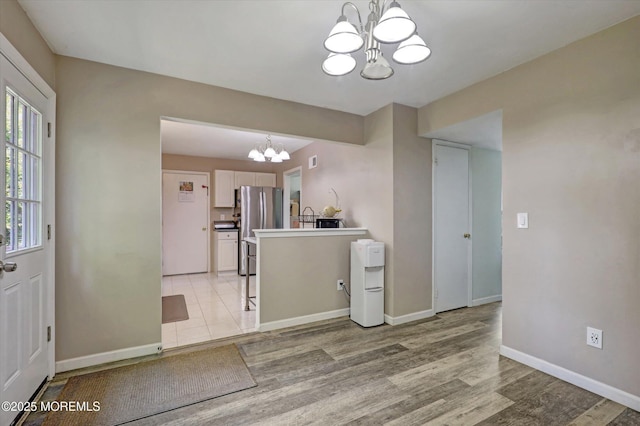 73 Barnegat Blvd S, Barnegat, NJ 08005 - kitchen featuring a chandelier, freestanding refrigerator, light wood finished floors, white cabinetry, and pendant lighting