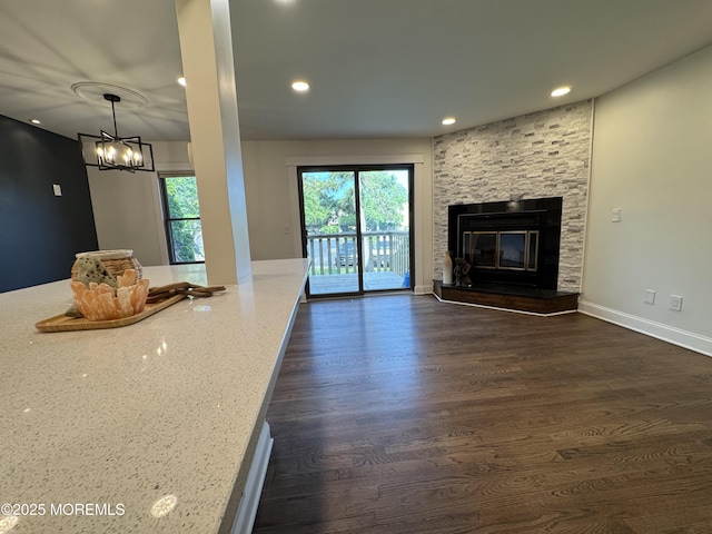 3 Churchill Downs, West Long Branch, NJ 07764 - unfurnished living room featuring recessed lighting, dark wood finished floors, a stone fireplace, and a chandelier