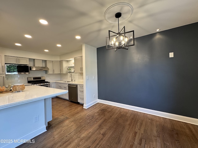 3 Churchill Downs, West Long Branch, NJ 07764 - kitchen featuring stainless steel appliances, wall chimney range hood, decorative backsplash, gray cabinets, and dark wood-style floors