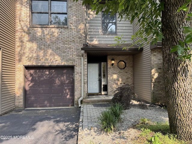 3 Churchill Downs, West Long Branch, NJ 07764 - property entrance with brick siding, an attached garage, and asphalt driveway