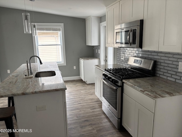 530 E Point Pleasant Ave, Ocean Gate, NJ 08740 - kitchen featuring stainless steel appliances, decorative backsplash, wood finished floors, and light stone countertops