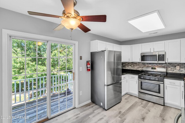 2211 Timber Ridge Ct Unit 2211, Sayreville, NJ 08859 - kitchen with appliances with stainless steel finishes, dark countertops, decorative backsplash, light wood-style floors, and white cabinetry