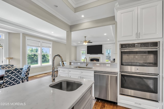 1605 Lakewood Rd, Manasquan, NJ 08736 - kitchen featuring stainless steel appliances, crown molding, dark wood-style flooring, ceiling fan, and light stone countertops