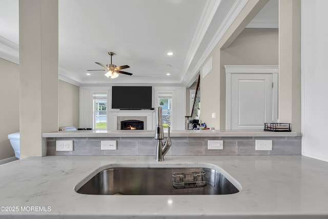 1605 Lakewood Rd, Manasquan, NJ 08736 - kitchen with crown molding, recessed lighting, light stone counters, a warm lit fireplace, and ceiling fan