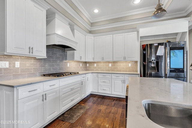 1605 Lakewood Rd, Manasquan, NJ 08736 - kitchen featuring stainless steel appliances, custom exhaust hood, ornamental molding, light stone countertops, and white cabinets