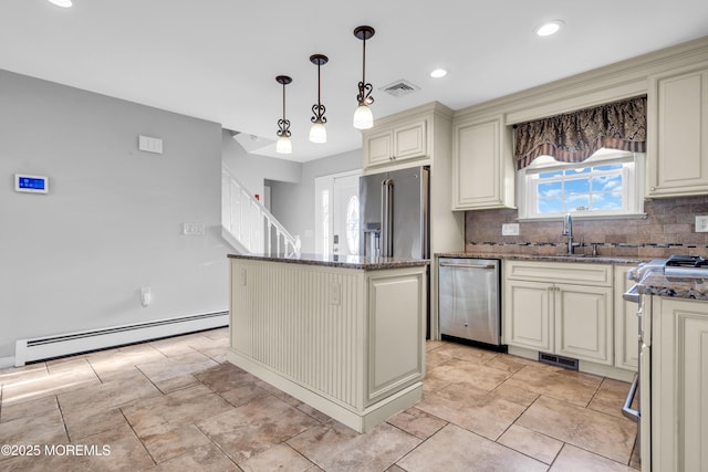 91 Wind Jammer Ct, Bayville, NJ 08721 - kitchen featuring baseboard heating, cream cabinetry, stainless steel appliances, dark stone countertops, and a kitchen island