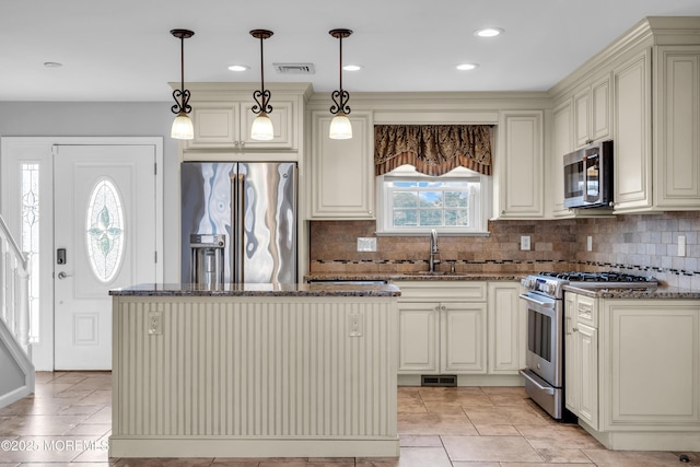 91 Wind Jammer Ct, Bayville, NJ 08721 - kitchen with appliances with stainless steel finishes, dark stone counters, tasteful backsplash, a kitchen island, and cream cabinetry