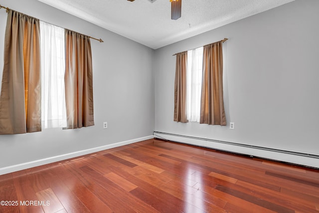 91 Wind Jammer Ct, Bayville, NJ 08721 - empty room featuring a ceiling fan, a baseboard heating unit, hardwood / wood-style floors, and a textured ceiling