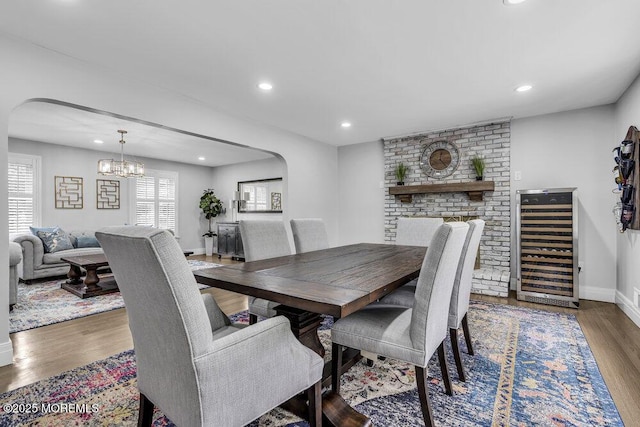 32 Blackbriar Dr, Colts Neck, NJ 07722 - dining room with beverage cooler, arched walkways, wood finished floors, a chandelier, and recessed lighting