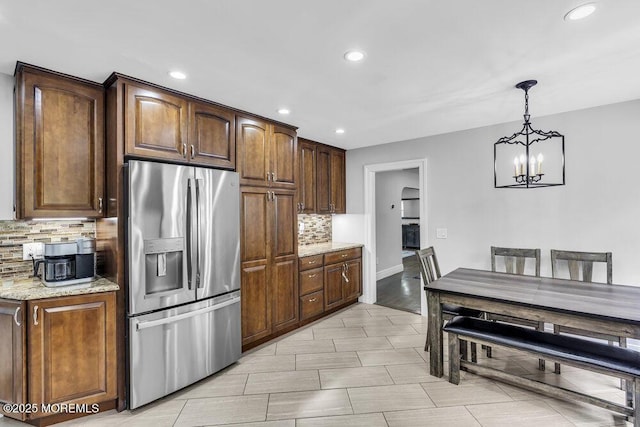 32 Blackbriar Dr, Colts Neck, NJ 07722 - kitchen with stainless steel refrigerator with ice dispenser, decorative backsplash, recessed lighting, a chandelier, and light stone counters