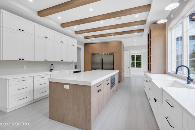 1423 Anthony Ct, Toms River, NJ 08753 - kitchen featuring built in appliances, a kitchen island, light countertops, beam ceiling, and white cabinetry
