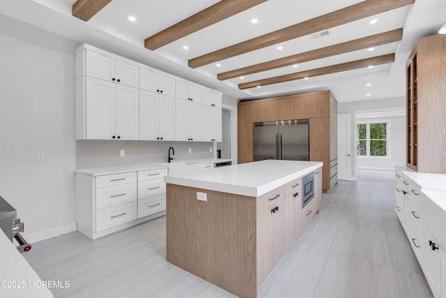 1423 Anthony Ct, Toms River, NJ 08753 - kitchen featuring built in appliances, a center island, light countertops, beamed ceiling, and white cabinetry